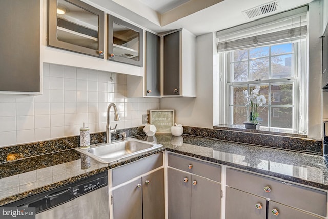 kitchen featuring a sink, tasteful backsplash, dishwasher, gray cabinetry, and visible vents