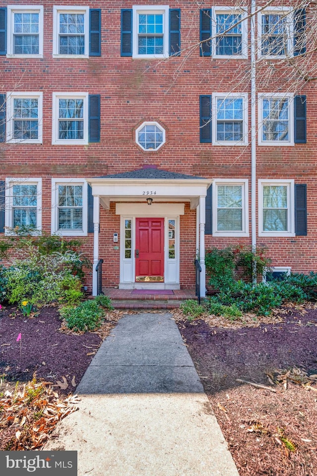 view of exterior entry with brick siding