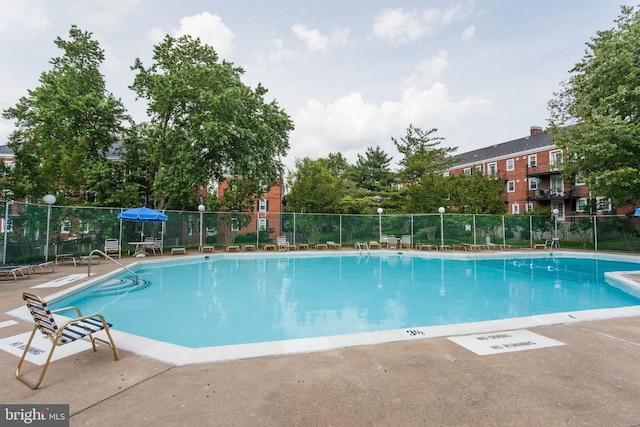 pool featuring fence and a patio area
