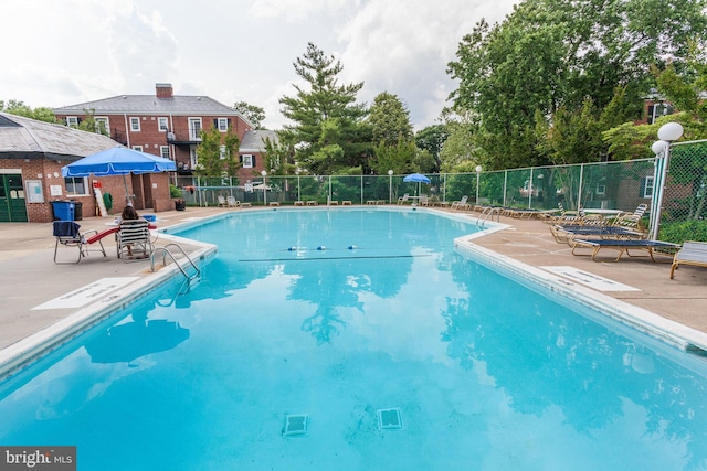 pool featuring fence and a patio