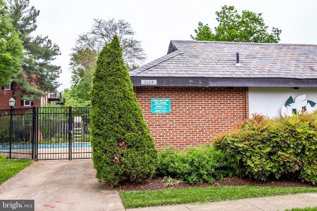 view of property exterior featuring a pool and fence