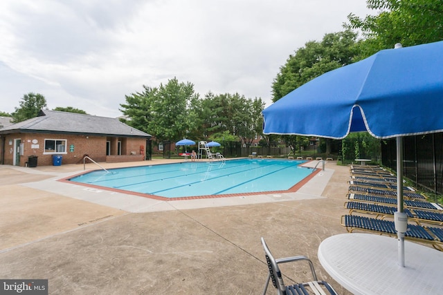 pool featuring fence and a patio