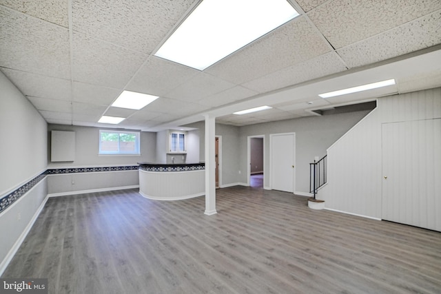 8012 Exodus Dr, Gaithersburg, MD 20882 - below grade area with wood finished floors, a drop ceiling, stairs, and baseboards