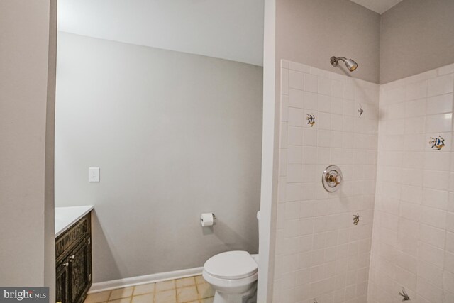 8012 Exodus Dr, Gaithersburg, MD 20882 - bathroom with a tile shower, toilet, vanity, and baseboards