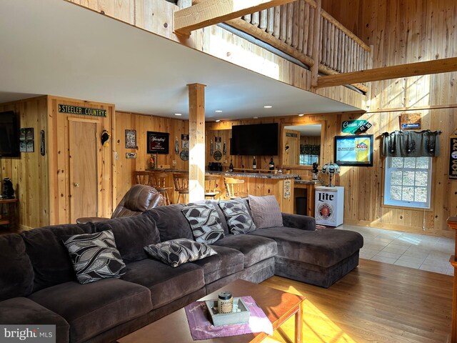 385 Elk Crk, Aaronsburg, PA 16820 - living room with a high ceiling, wood walls, and light wood-type flooring