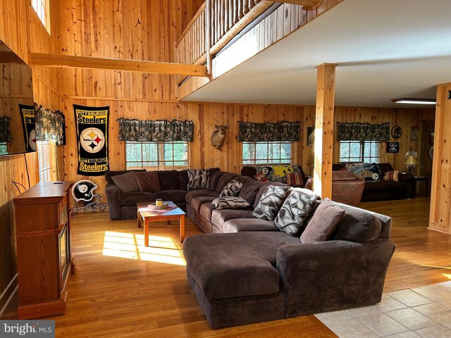385 Elk Crk, Aaronsburg, PA 16820 - living room featuring a towering ceiling, wood walls, and light wood-style floors