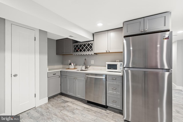 205 16th St SE, Washington, DC 20003 - kitchen featuring stainless steel appliances, gray cabinets, light wood-style flooring, light countertops, and recessed lighting