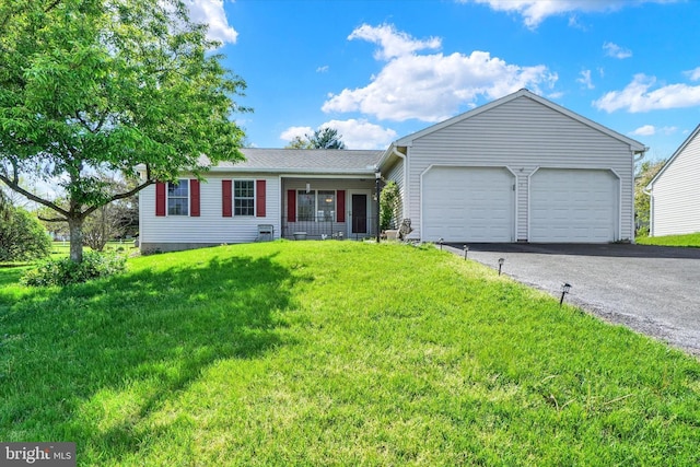 ranch-style home with an attached garage, a front yard, and aphalt driveway