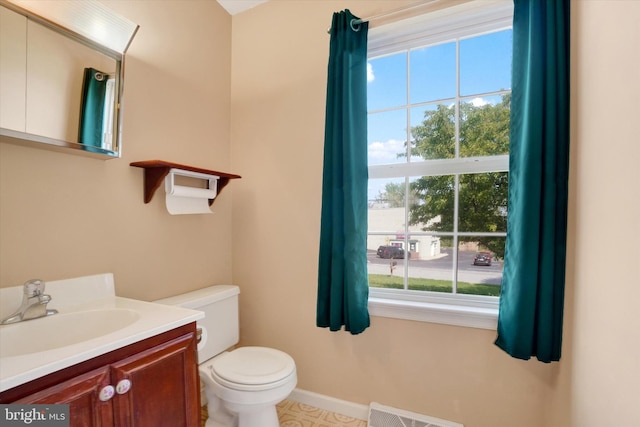 half bath with visible vents, baseboards, toilet, and vanity