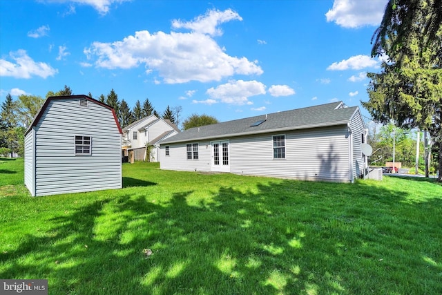 back of house with an outdoor structure and a yard