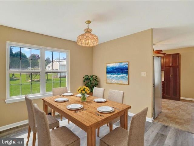dining area with baseboards, plenty of natural light, and light wood-style flooring