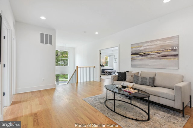 living area featuring visible vents, recessed lighting, baseboards, and wood finished floors