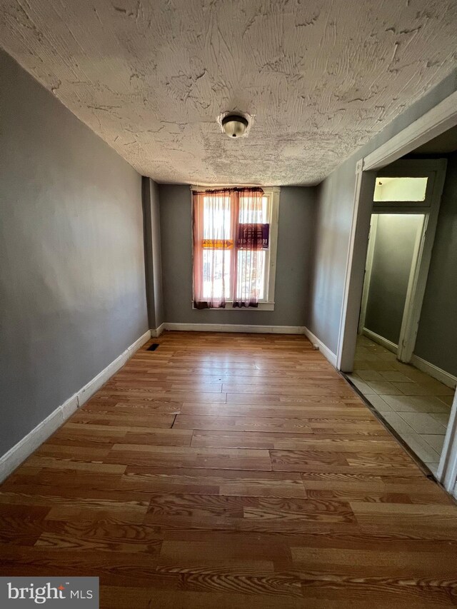 211 S Hilton St, Baltimore, MD 21229 - empty room with a textured ceiling, baseboards, and wood finished floors