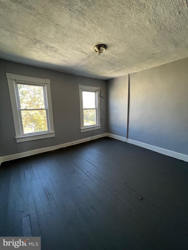 211 S Hilton St, Baltimore, MD 21229 - unfurnished room with dark wood-style floors, baseboards, and a textured ceiling