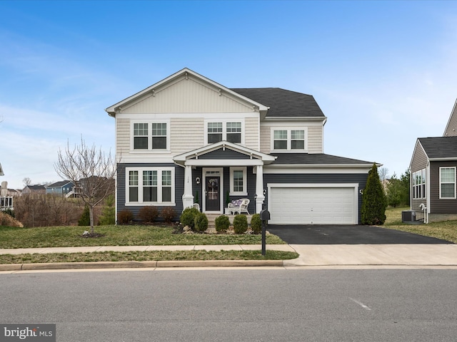 view of front of property featuring driveway, cooling unit, and an attached garage