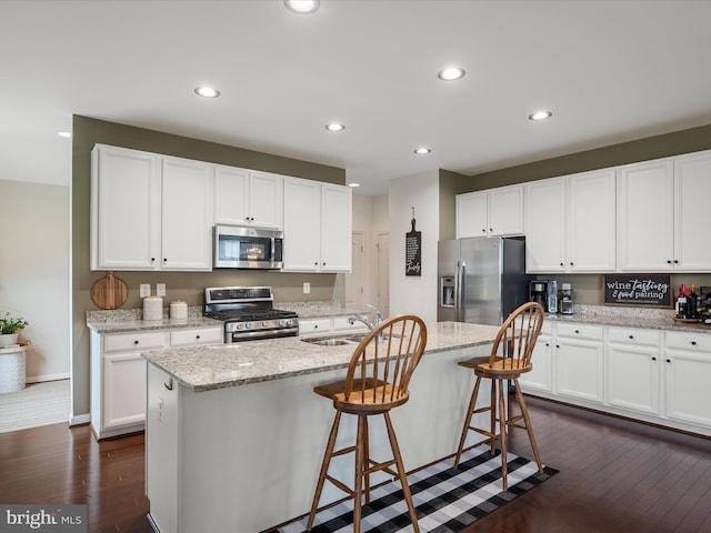 kitchen featuring a sink, white cabinetry, appliances with stainless steel finishes, and dark wood-type flooring