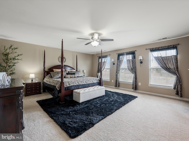 bedroom featuring light colored carpet, visible vents, baseboards, and a ceiling fan