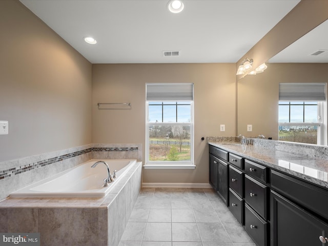 bathroom with tile patterned floors, vanity, a bath, and visible vents