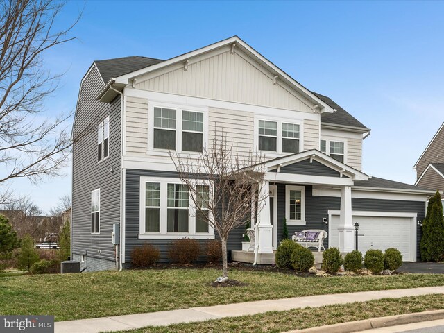 view of front of property featuring a front yard, driveway, central air condition unit, and an attached garage