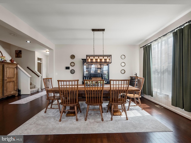 dining space featuring stairs, visible vents, and wood-type flooring