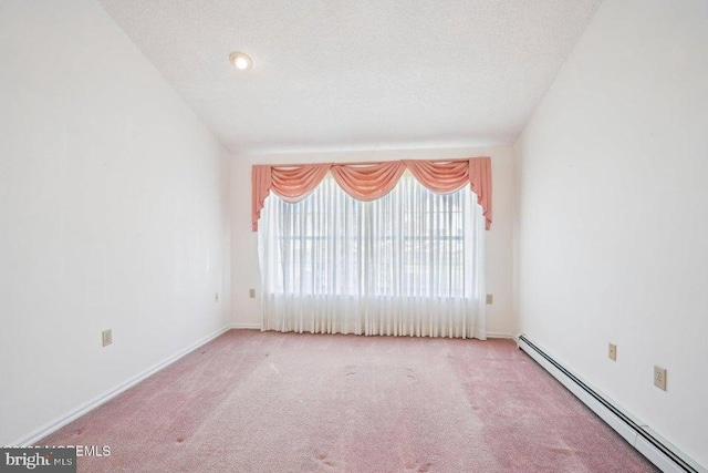 empty room with baseboards, baseboard heating, carpet, and a textured ceiling