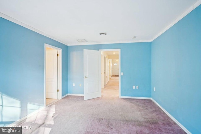 unfurnished bedroom with carpet, baseboards, visible vents, and crown molding