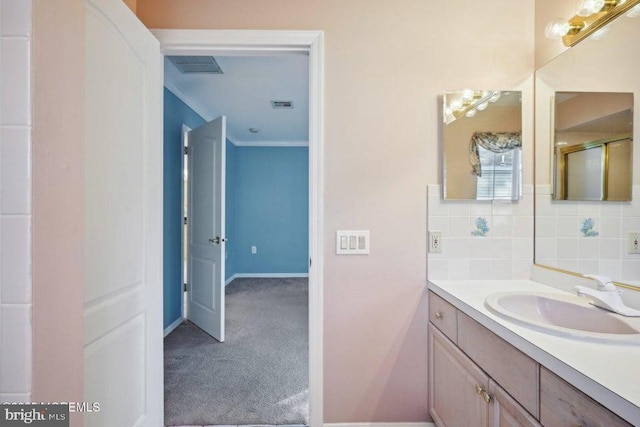 bathroom featuring vanity, tasteful backsplash, crown molding, baseboards, and visible vents