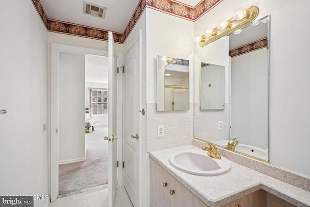 bathroom featuring visible vents, decorative backsplash, and vanity
