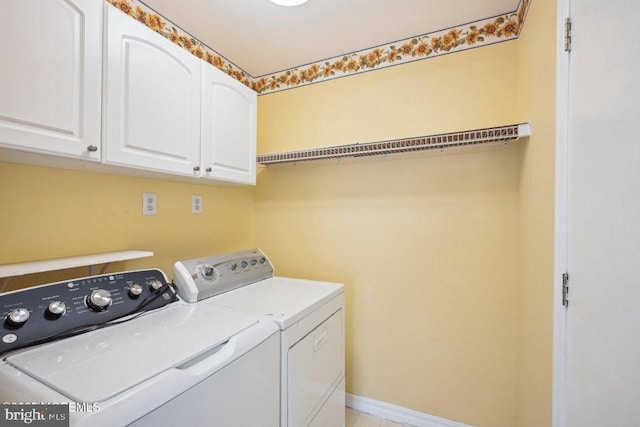 laundry room with cabinet space, baseboards, and separate washer and dryer