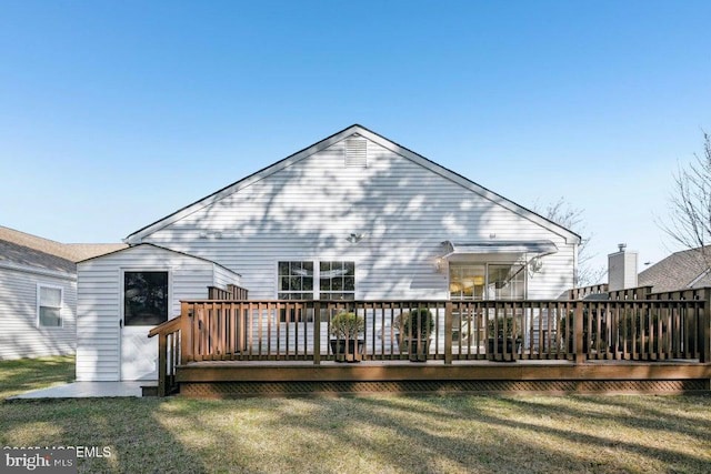 back of property featuring a deck and a yard