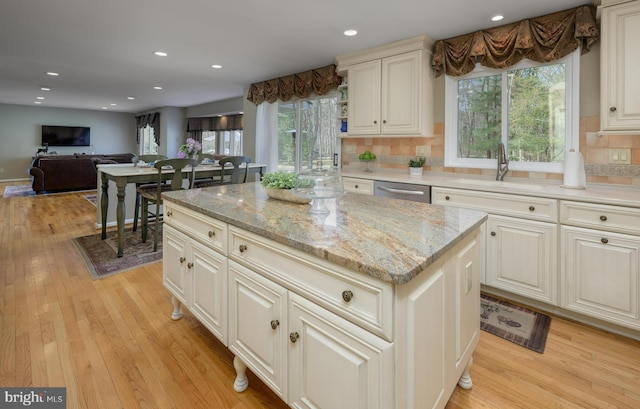 kitchen with plenty of natural light, dishwasher, a sink, and tasteful backsplash