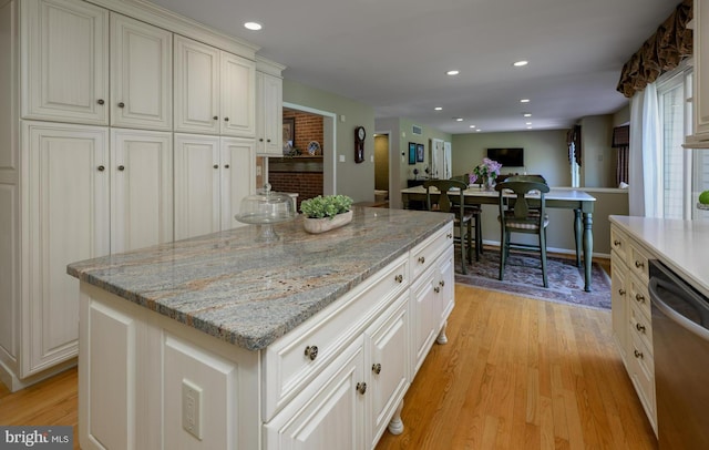 kitchen with recessed lighting, stainless steel dishwasher, light wood-style floors, and a kitchen island