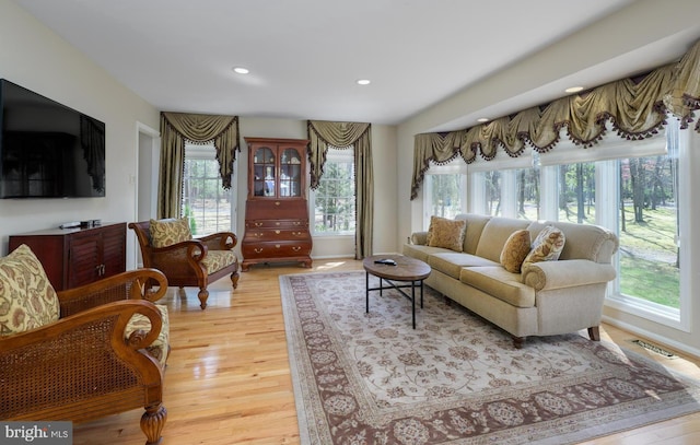 living room with a wealth of natural light, light wood finished floors, visible vents, and recessed lighting