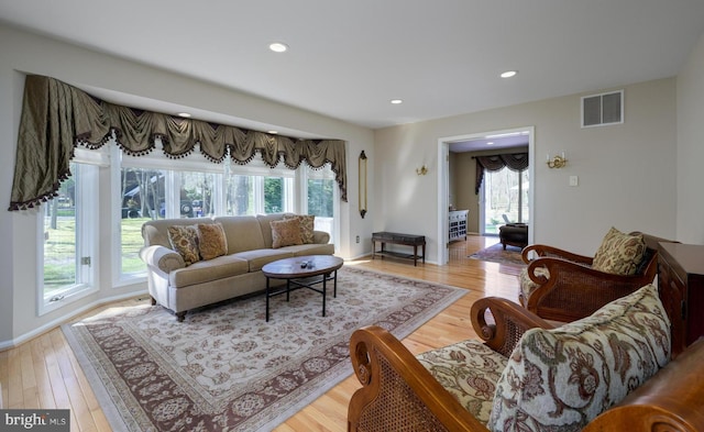 living area featuring light wood-style flooring, visible vents, recessed lighting, and a healthy amount of sunlight