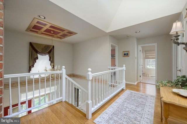 corridor with baseboards, wood finished floors, recessed lighting, and an upstairs landing