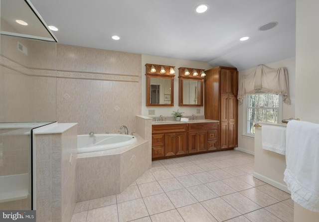 full bathroom featuring a bath, a sink, tile patterned flooring, and double vanity