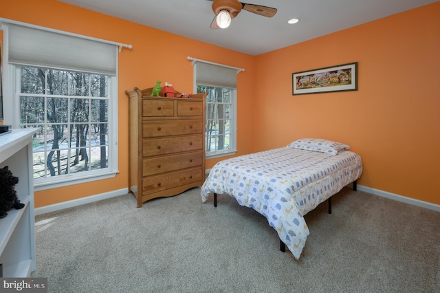 bedroom featuring ceiling fan, carpet floors, baseboards, and multiple windows