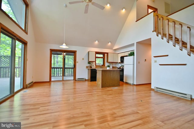 277 Anderson Rd, Basye, VA 22810 - unfurnished living room featuring baseboard heating, high vaulted ceiling, light wood finished floors, ceiling fan, and healthy amount of natural light