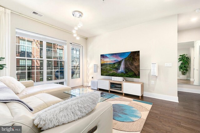 living room with baseboards, wood finished floors, and visible vents