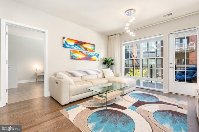 living area featuring baseboards, wood finished floors, and visible vents