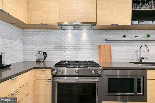 kitchen featuring backsplash, dark countertops, a sink, stainless steel appliances, and extractor fan
