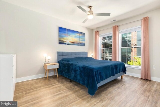 bedroom with visible vents, baseboards, ceiling fan, and wood finished floors