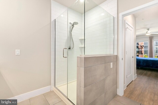 ensuite bathroom with baseboards, a shower stall, ensuite bathroom, and tile patterned flooring