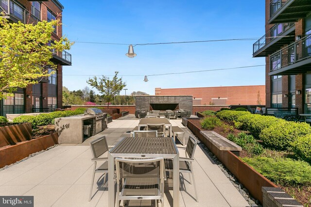 view of patio / terrace with an outdoor living space with a fireplace, a grill, and area for grilling