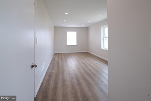 spare room featuring plenty of natural light, visible vents, wood finished floors, and recessed lighting
