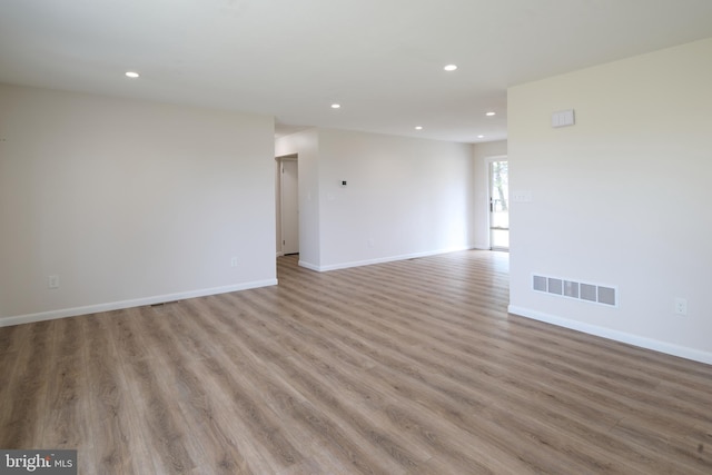 unfurnished room featuring baseboards, visible vents, wood finished floors, and recessed lighting
