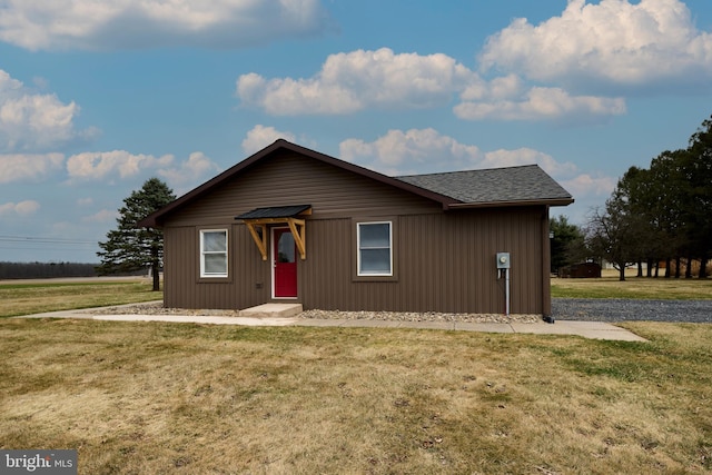 view of front of home with a shingled roof and a front lawn