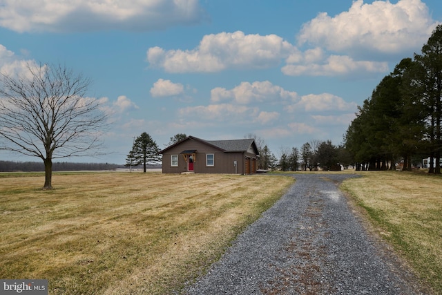 view of front of property with a front lawn and gravel driveway