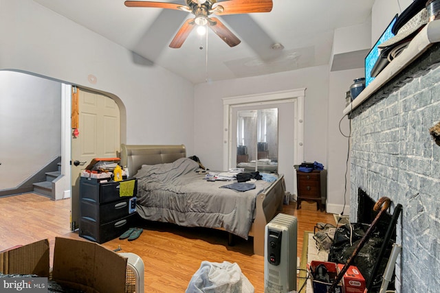 2609 Keyworth Ave, Baltimore, MD 21215 - bedroom featuring light wood-style floors, ceiling fan, arched walkways, vaulted ceiling, and a brick fireplace