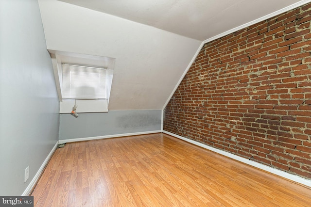 2609 Keyworth Ave, Baltimore, MD 21215 - unfurnished room with light wood-type flooring, brick wall, baseboards, and vaulted ceiling